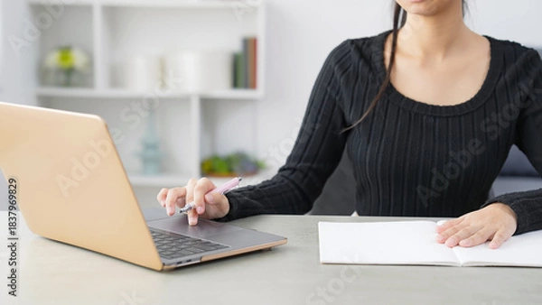 Obraz 部屋でノートパソコンを見ながら勉強する女性