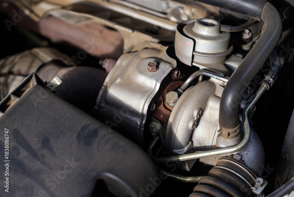 Fototapeta Close-up of car turbocharger system showing engine detail, metal texture, and automotive technology concept