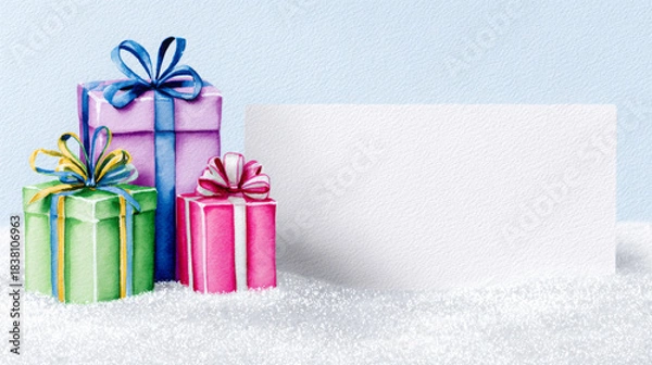 Obraz Colorful gift boxes in green, pink, and purple with decorative ribbons are placed on a snowy surface, featuring a blank card for personalized messages and holiday greetings