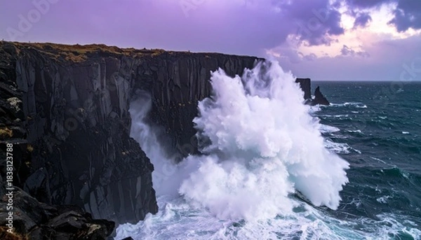 Obraz Huge waves collide with dark jagged cliffs along the coast creating a dramatic spray of white water under a moody sky