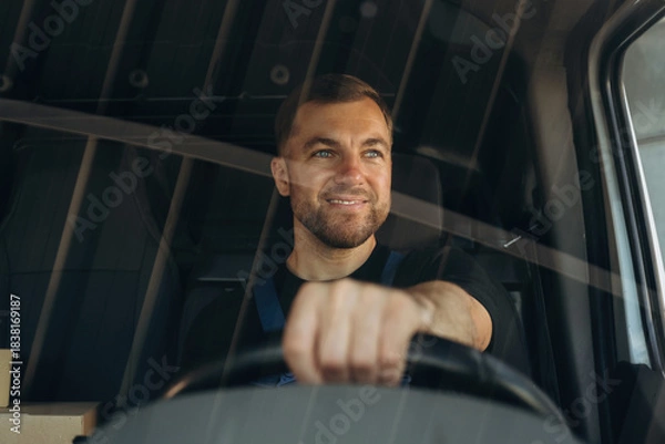 Obraz Front view of delivery man that is driving a van