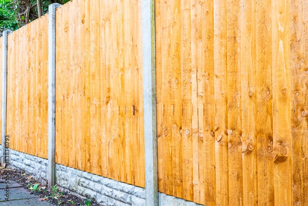Fototapeta A three quarter view of brand new fence panels in the garden with concrete posts