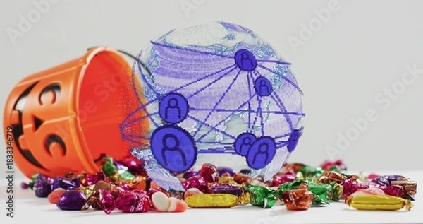 Fototapeta Showing translucent globe over white tabletop, orange jack-o'-lantern candy bucket spilling candies