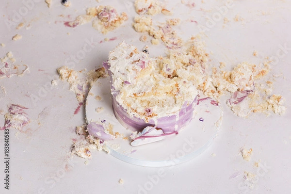 Fototapeta Smashed cake on white table for first birthday. Messy pieces