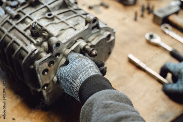 Obraz Disassembled old car gearbox with gears in an auto service garage. Repair, maintenance, and replacement of worn mechanical transmission parts in a vehicle