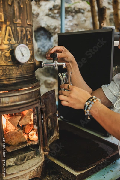 Obraz Woman's hand pouring tea from samovar
