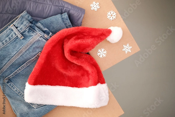 Obraz Christmas donation box for charity with red Santa hat. Cardboard box full of clothing for poor families, homeless people