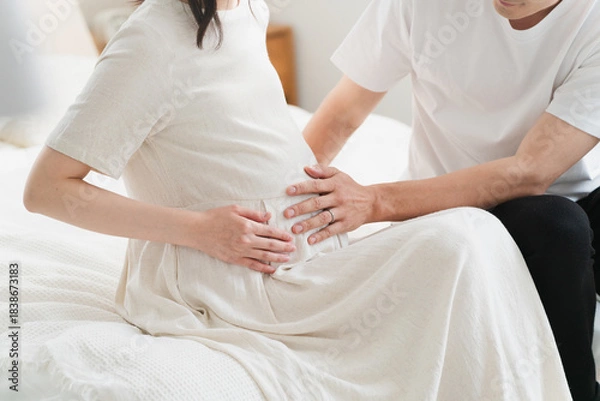 Fototapeta ベッドでくつろいでいる妊婦と夫　ライフスタイルイメージ