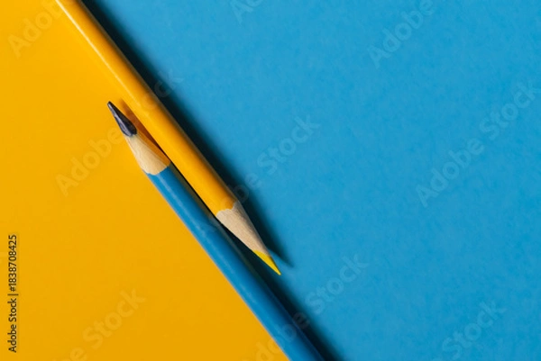 Fototapeta Teal and yellow colored pencil on the same colored paper