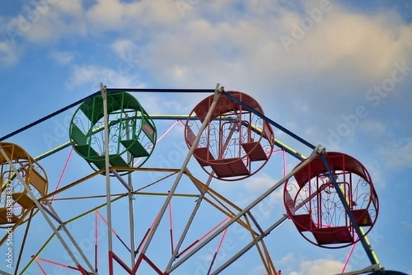 Obraz A simple ferris wheel against a blue sky background.