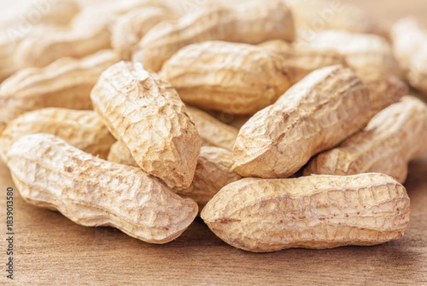 Fototapeta Closeup view of fresh peanuts on wooden table