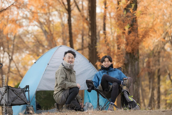Fototapeta 秋のキャンプ場で笑顔の男性2人がテント前でカメラ目線の笑顔