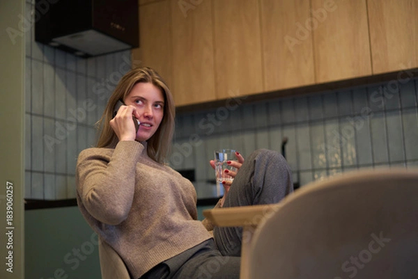 Obraz Casual Conversation Over the Phone at the Kitchen Table