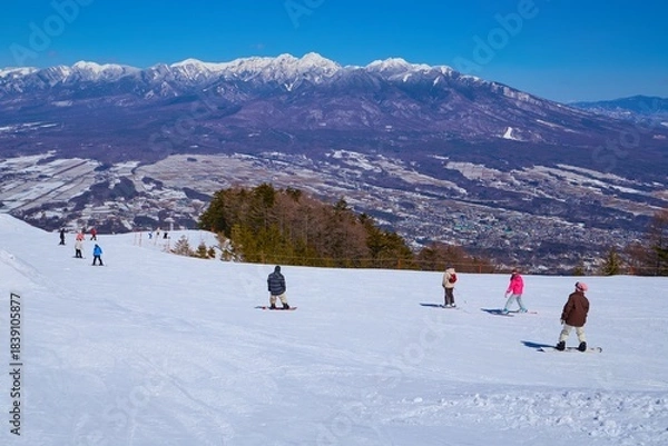 Obraz 冬の長野県富士見町の富士見パノラマリゾートのゴンドラ山頂駅付近から八ヶ岳連峰のパノラマ風景とスキーヤー等を見る
