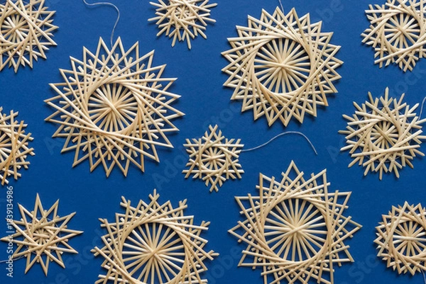 Obraz Snowflakes are made of straw on a blue background. Christmas decor. Top view. Straw weaving. Lutsk, Ukraine