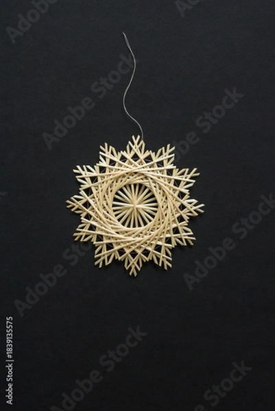 Obraz Snowflakes are made of straw on a black background. Straw snowflakes. Christmas decor. Top view. Straw weaving. Lutsk, Ukraine
