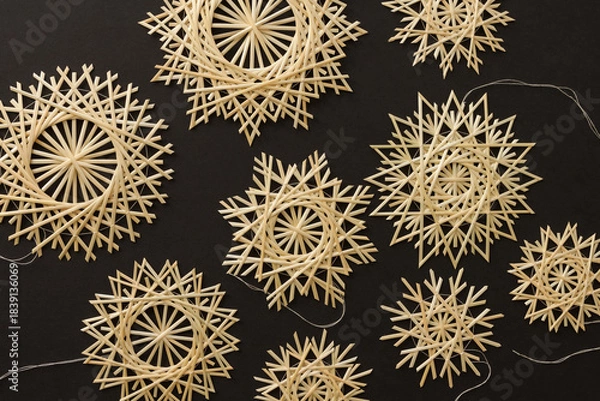 Obraz Snowflakes are made of straw on a black background. Straw snowflakes. Christmas decor. Top view. Straw weaving. Lutsk, Ukraine