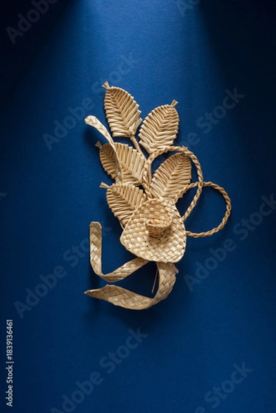 Obraz Decoration of straw on a blue background. Branch with flowers. Boutonniere made out of straw. Brooch. Straw weaving.