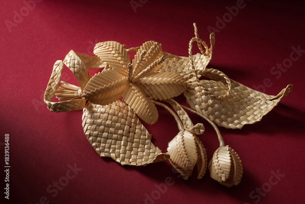 Obraz Decoration of straw on a red background. Branch with flowers. Boutonniere made out of straw. Brooch. Straw weaving.