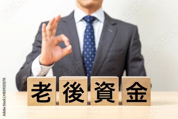 Obraz 「老後資金」と書かれたブロックとOKポーズをするビジネスマン