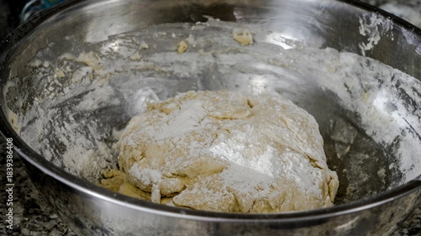 Fototapeta Dough is mixed in a bowl on a countertop in a kitchen while preparing for baking