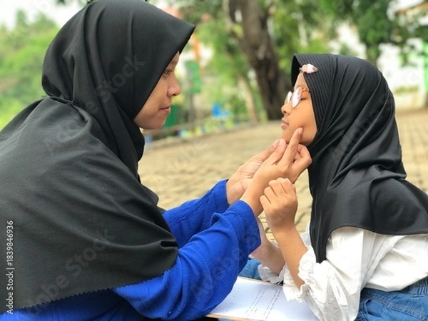 Obraz Mom Gently Holding Her Daughter’s Cheek as They Smile at Each Other