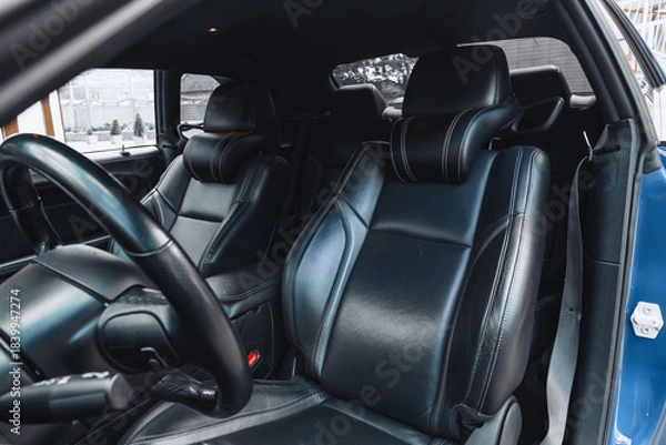 Fototapeta Luxury car interior features sleek black leather seats and modern design elements
