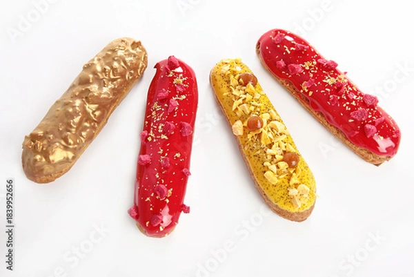 Fototapeta Glazed eclairs on a white background. A set of eclairs on a white background. French classic dessert. An isolated object.