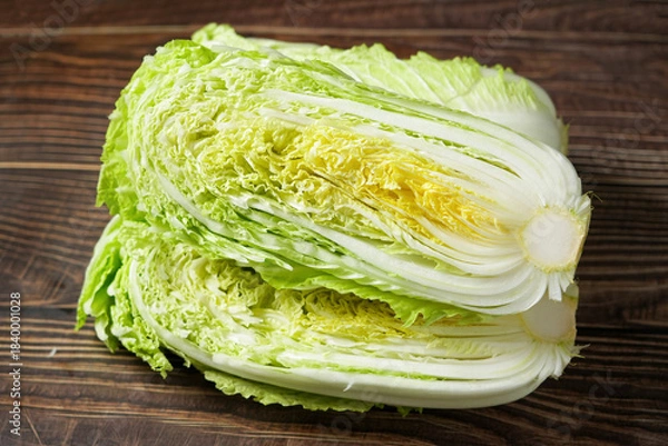 Obraz fresh chinese cabbage and a cut one on wood table.