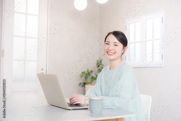 Fototapeta 自宅やカフェでパソコンをする笑顔のかわいい女性　　カメラ目線	