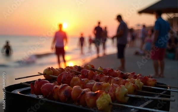 Fototapeta Beach barbecue with skewers grilling and people enjoying the sunset, creating a vibrant and festive atmosphere by the sea. High quality