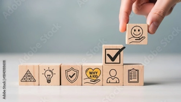 Obraz Hand placing a wooden block with a happy face icon on top of a checkmark block symbolizing success and achievement