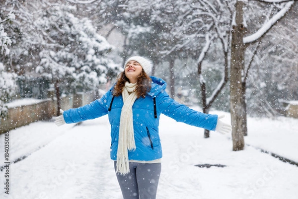 Fototapeta Young woman enjoying a snowy winter day