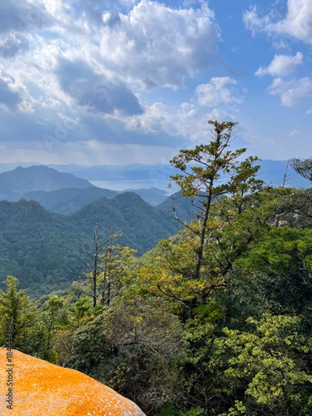 Obraz Mountain valley with sunlight and clouds over forest
