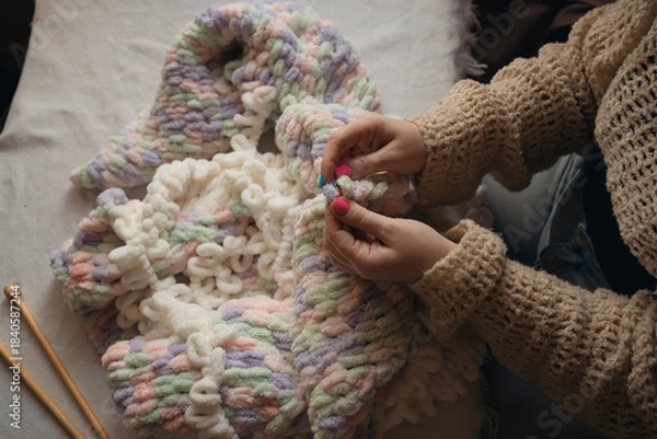Obraz Hands making blanket from yarn without crochet hook or knitting needles