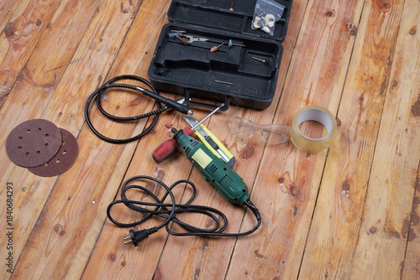 Obraz Working tools for repairs on a wooden floor.