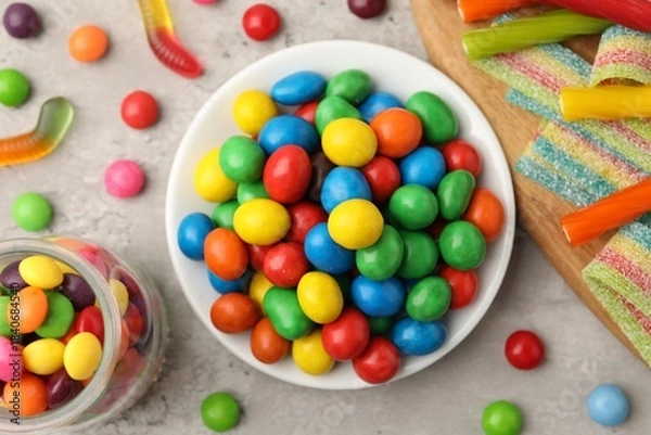 Obraz Delicious colorful candies on light table, flat lay