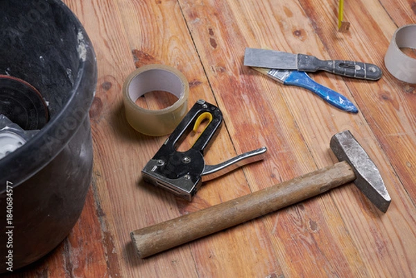 Obraz Working tools for repairs on a wooden floor.