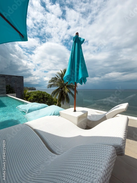 Fototapeta View from luxury villa at sunny day, sun loungers for sunbathing, umbrellas from the sun, pillows for swimming in the pool, palm tree on background