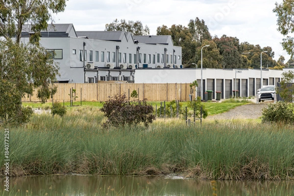 Obraz Modern townhouses in Point Cook, Melbourne, overlooking wetland reeds and landscaped green space. Concept of suburban–nature interface, urban conservation, contemporary Australian neighbourhood
