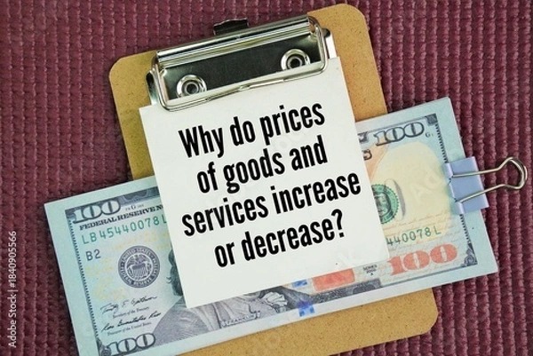 Obraz Paper money and a whiteboard with the words of a question about economics, namely Why do prices of goods and services increase or decrease?