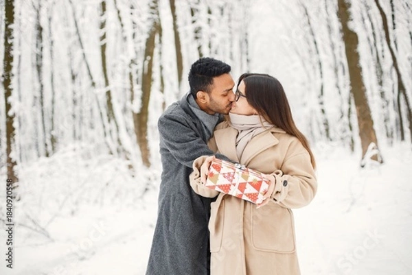 Fototapeta Portrait of a romantic couple spending time together in winter forest