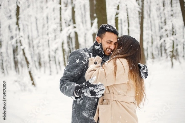 Fototapeta Portrait of a romantic couple spending time together in winter forest
