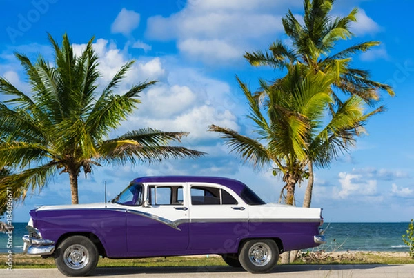 Fototapeta Amerikanischer blau weisser Ford Fairlane Oldtimer parkt am Strand unter Palmen in Varadero Cuba - Serie Cuba Reportage