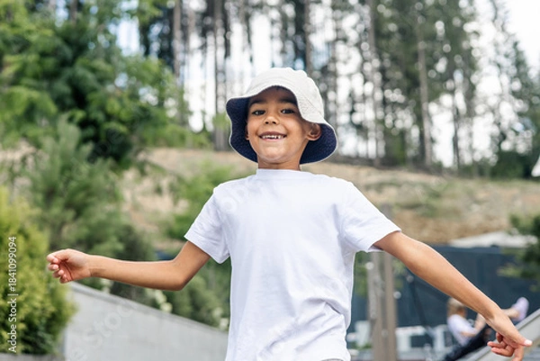 Obraz young mixed-race boy smiles while running towards trampoline