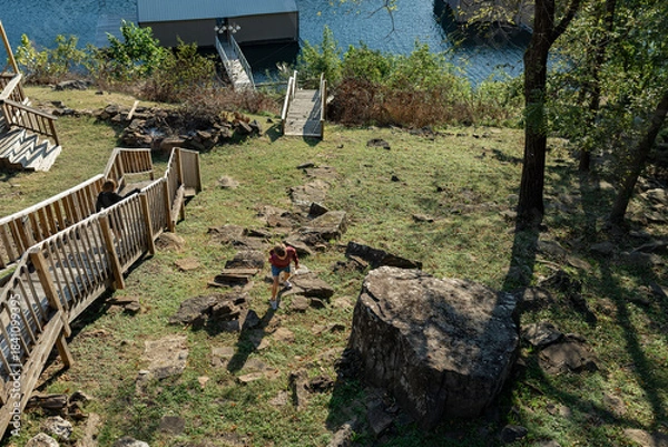 Fototapeta two boys walking around rocky hillside and wooden stairs