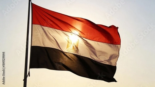 Obraz Vibrant Egyptian flag fluttering in the sunlight, ideal for patriotic themes, backgrounds, or cultural presentations.