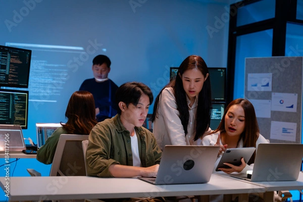 Fototapeta Asian software engineer or programmer team working late in development office,problem solving or algorithm of ai assistant helping for work.software developer,digital technology security concept