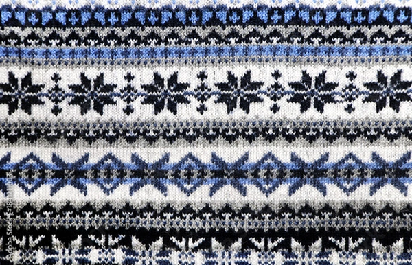 Obraz Wool sweater texture with decorative ornament of white, blue, and gray color. Natural wool material with knitted ornament. Horizontal or vertical Christmas background with knitted fabric texture