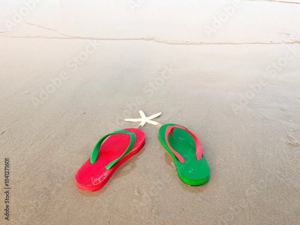 Obraz green and red sandals on summer beach background at sunset with copy space.